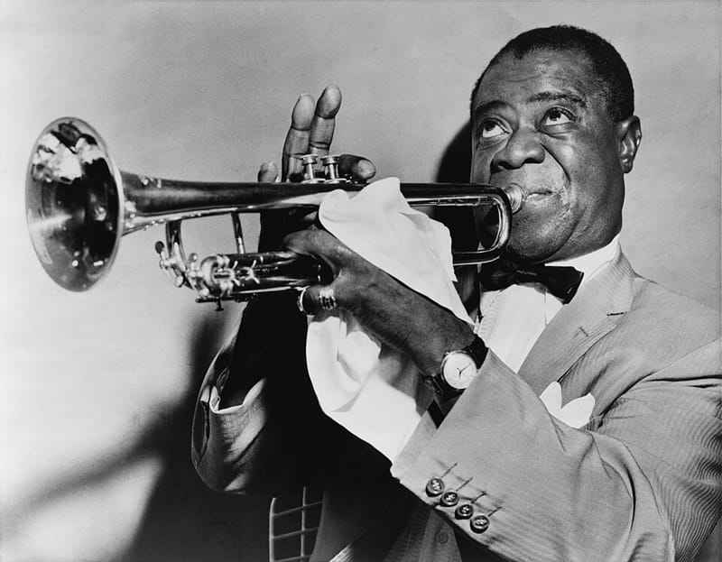 Louis Armstrong holding his trumpet, smiling