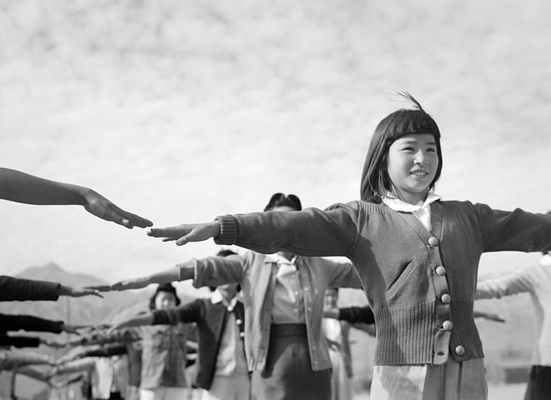 People exercising at Manzanar with mountains behind