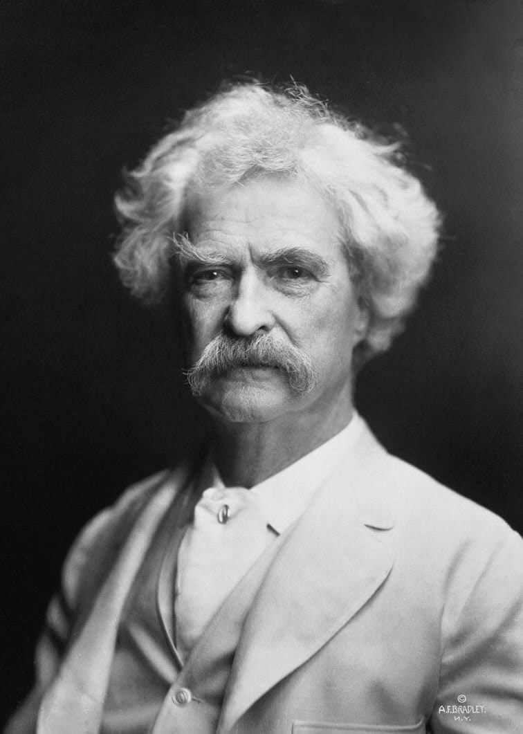 Mark Twain in a white suit, photographed in his later years